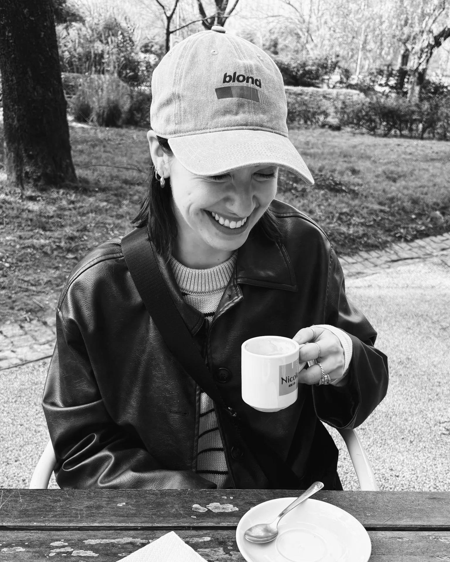 Grace smiling with a coffee in a park